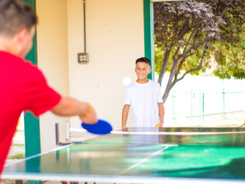 Two campers playing ping pong.