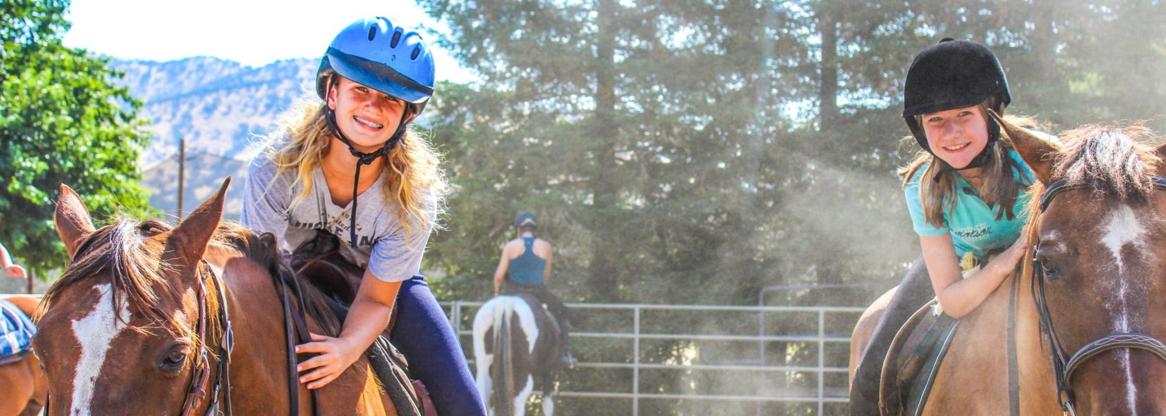 Campers smiling while riding horses